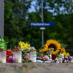 Kerzen und Blumen stehen am Tatort vor dem ehemaligen Bahnhofsgebäude in Friedland, Thüringen