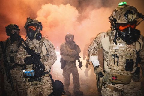 ICE-Beamte mit Gasmasken inmitten von Tränengas in Minneapolis, das sie abfeuern, um Demonstranten auseinanderzutreiben