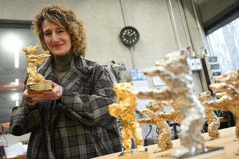 Festivalchefin Tricia Tuttle zeigt einen der Bären. Foto: Britta Pedersen/dpa