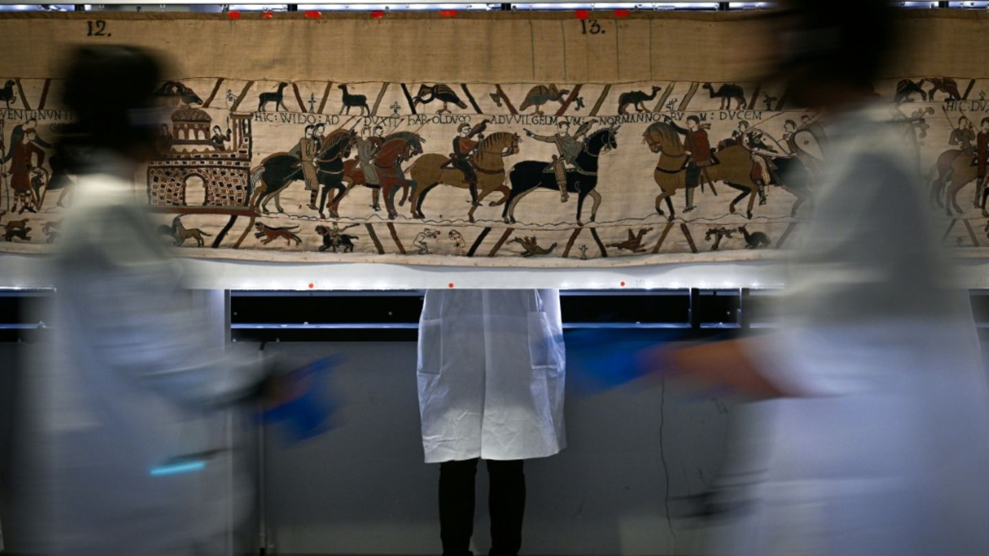 Helfer bei der Abhängung des Wandteppichs