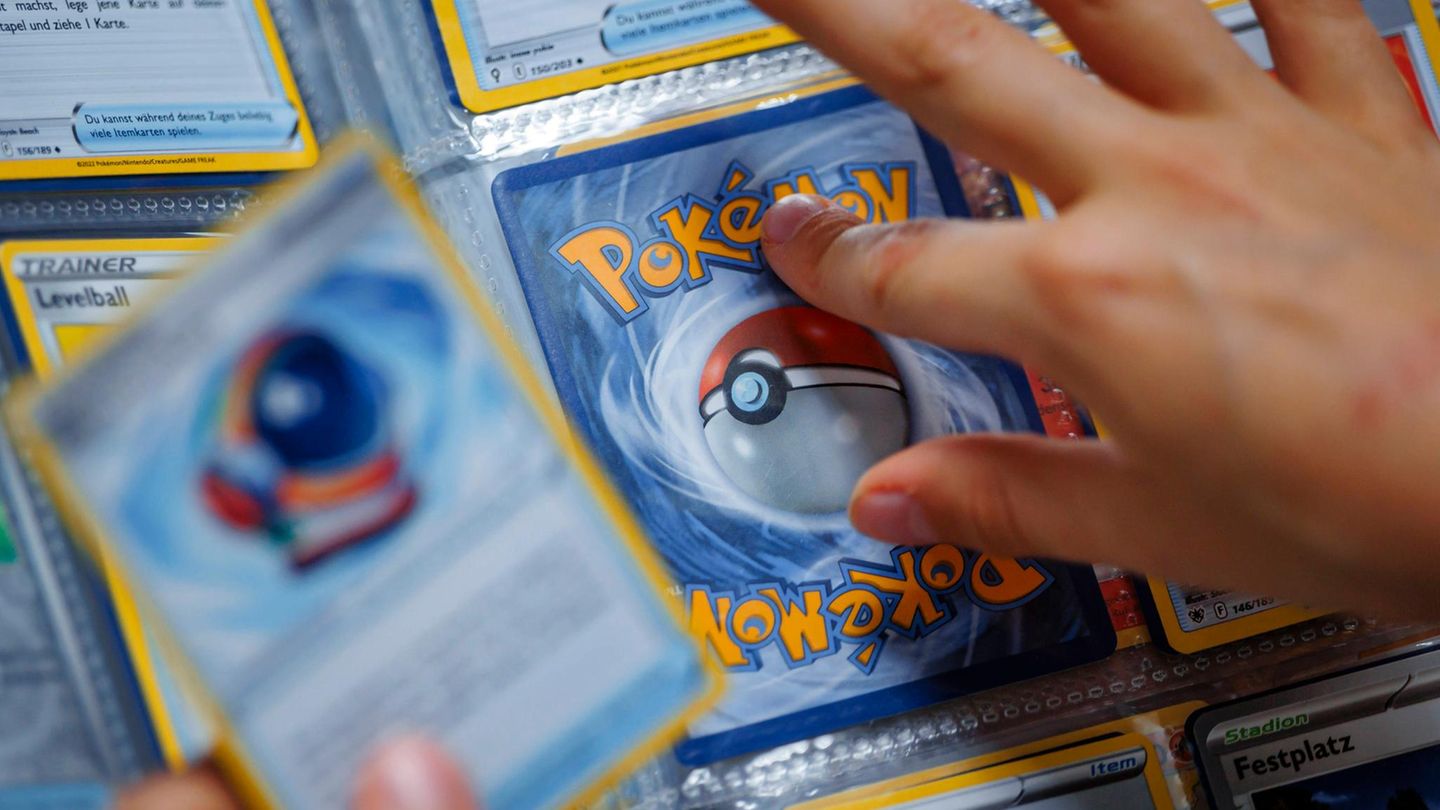 Eine Hand tippt auf eine Pokémon-Sammelkarte