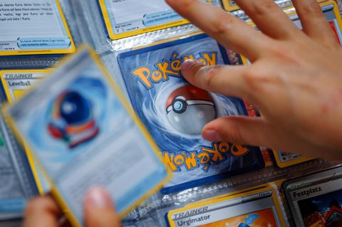 Eine Hand tippt auf eine Pokémon-Sammelkarte