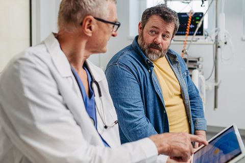 Ein Mann sitzt in einem Vorsorgegespräch beim Arzt