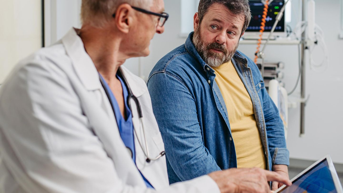 Ein Mann sitzt in einem Vorsorgegespräch beim Arzt