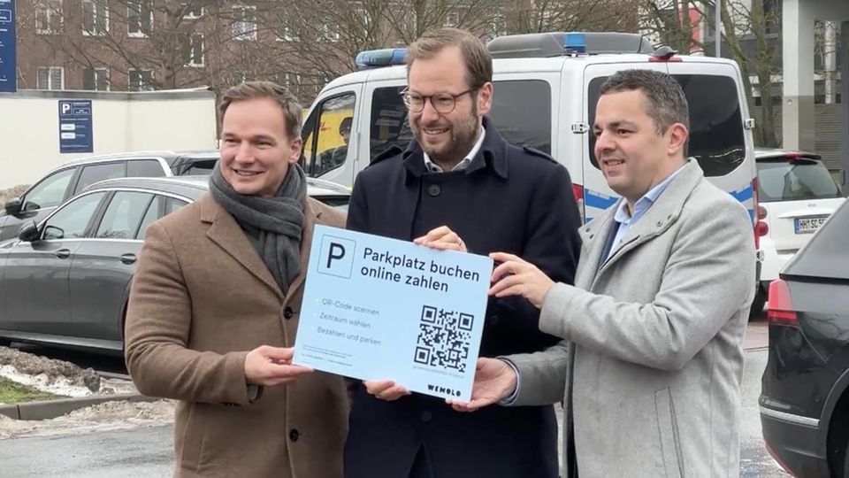Drei Männer stehen auf einem Parkplatz