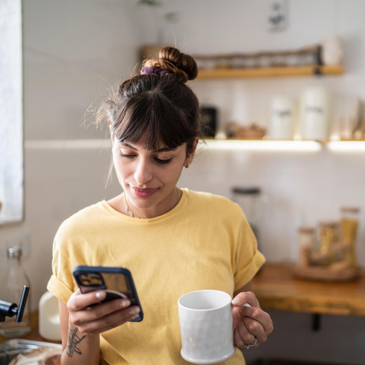 Eine Frau schaut auf das Smartphone, vermutlich nutzt sie Whatsapp