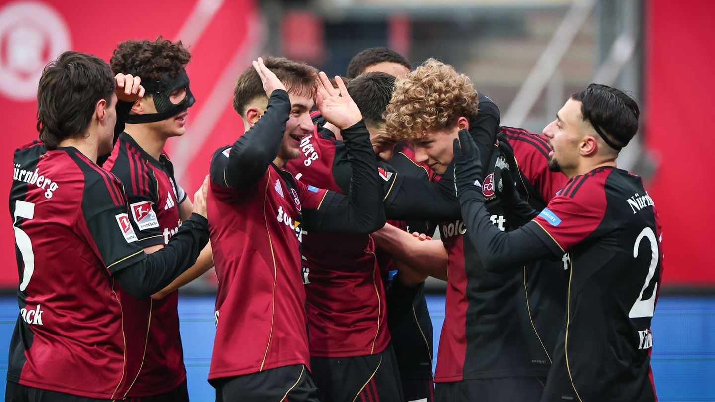 Seine Mitspieler wollen Matchwinner Piet Scobel gar nicht mehr loslassen. Foto: Daniel Karmann/dpa