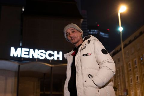 Valeri aus Bulgarien steht vor dem Schriftzug „Mensch“ auf dem Dach der Weißfrauenkirche im Bahnhofsviertel von Frankfurt. Foto: