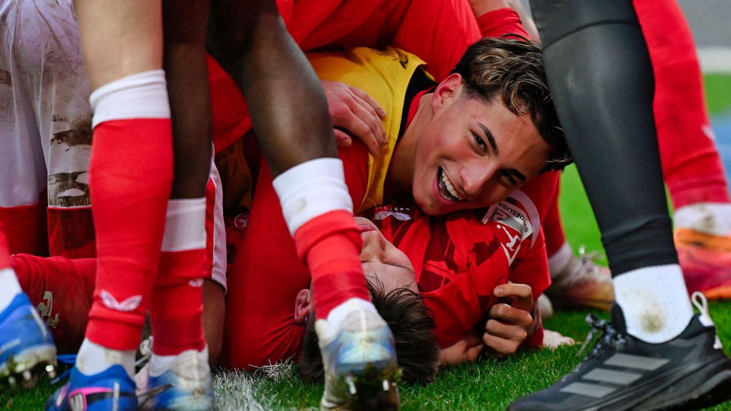 Naatan Skyttä wird von seinen FCK-Kollegen nach dem Sieg gegen Hannover unter sich begraben. Foto: Uwe Anspach/dpa