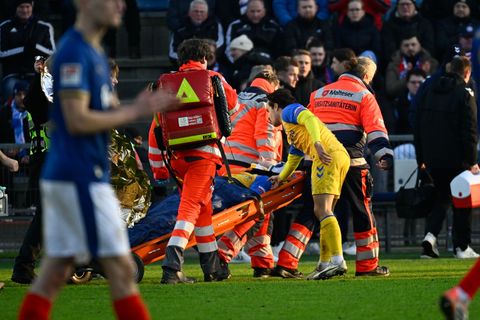 Paderborns Spieler Calvin Brackelmann wird nach einer Verletzung von Sanitätern auf einer Trage vom Spielfeld gebracht. Foto: Gr