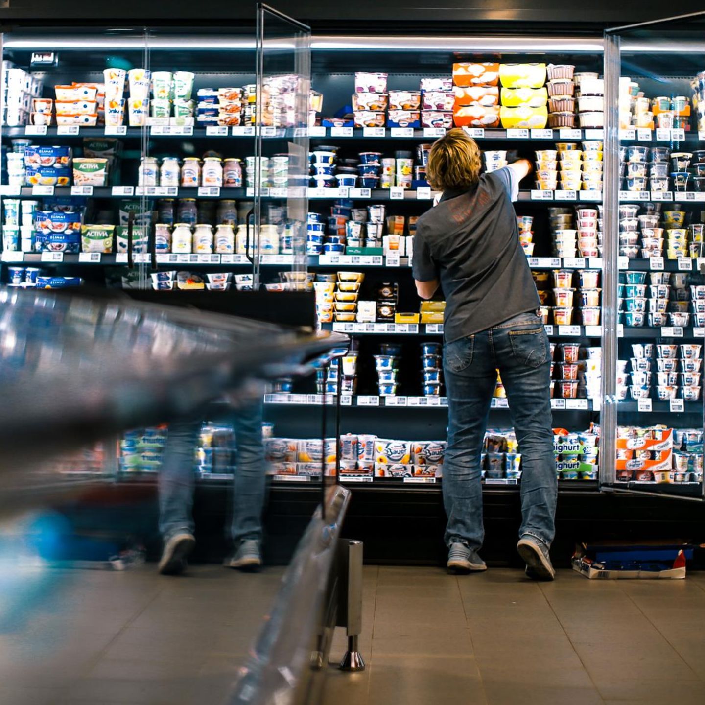 Eine Mitarbeiterin befüllt in einem Supermarkt Kühlregale: Im Einzelhandel gibt es besonders viele Minijobs
