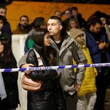 Menschen hinter einer Polizeiabsperrung am Unglücksort