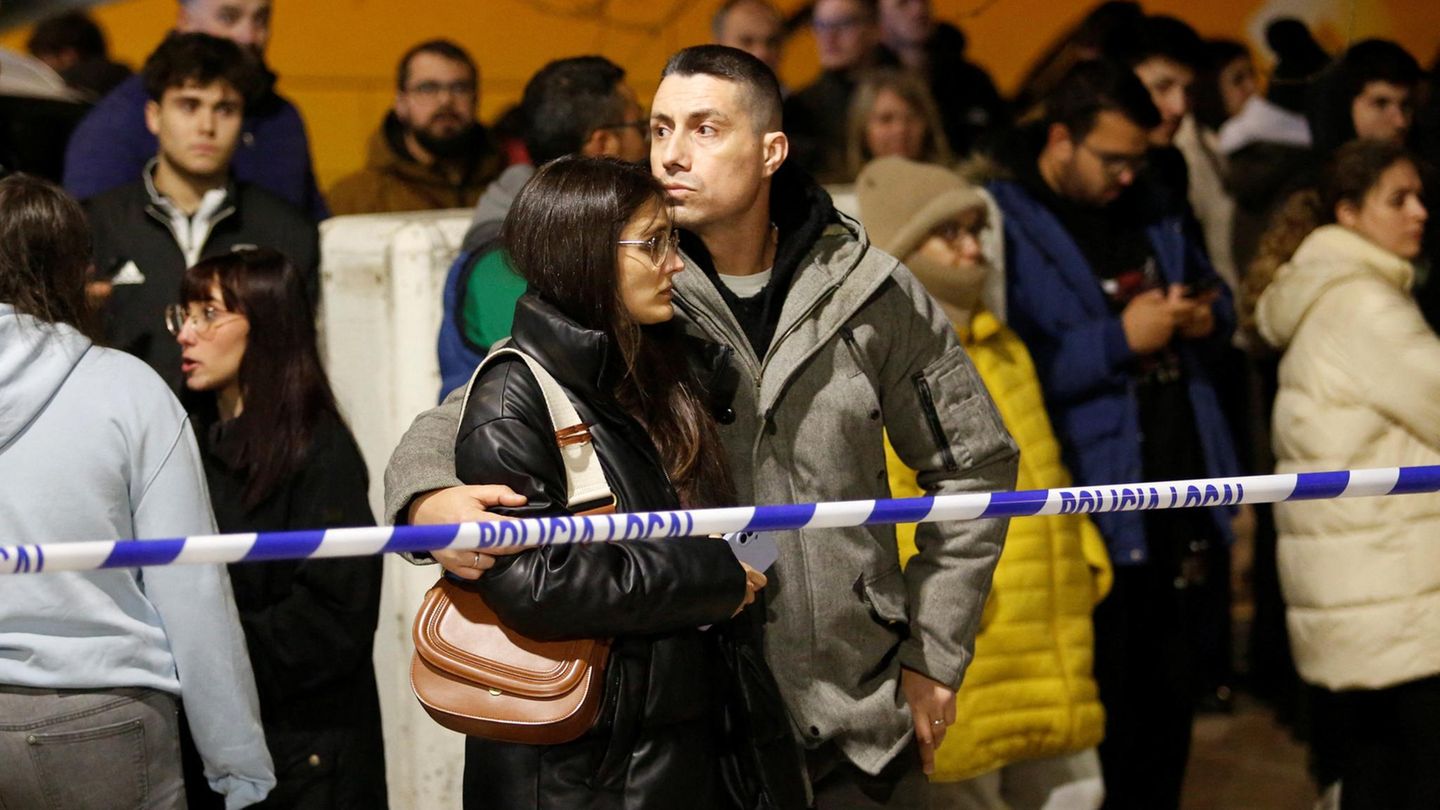 Menschen hinter einer Polizeiabsperrung am Unglücksort