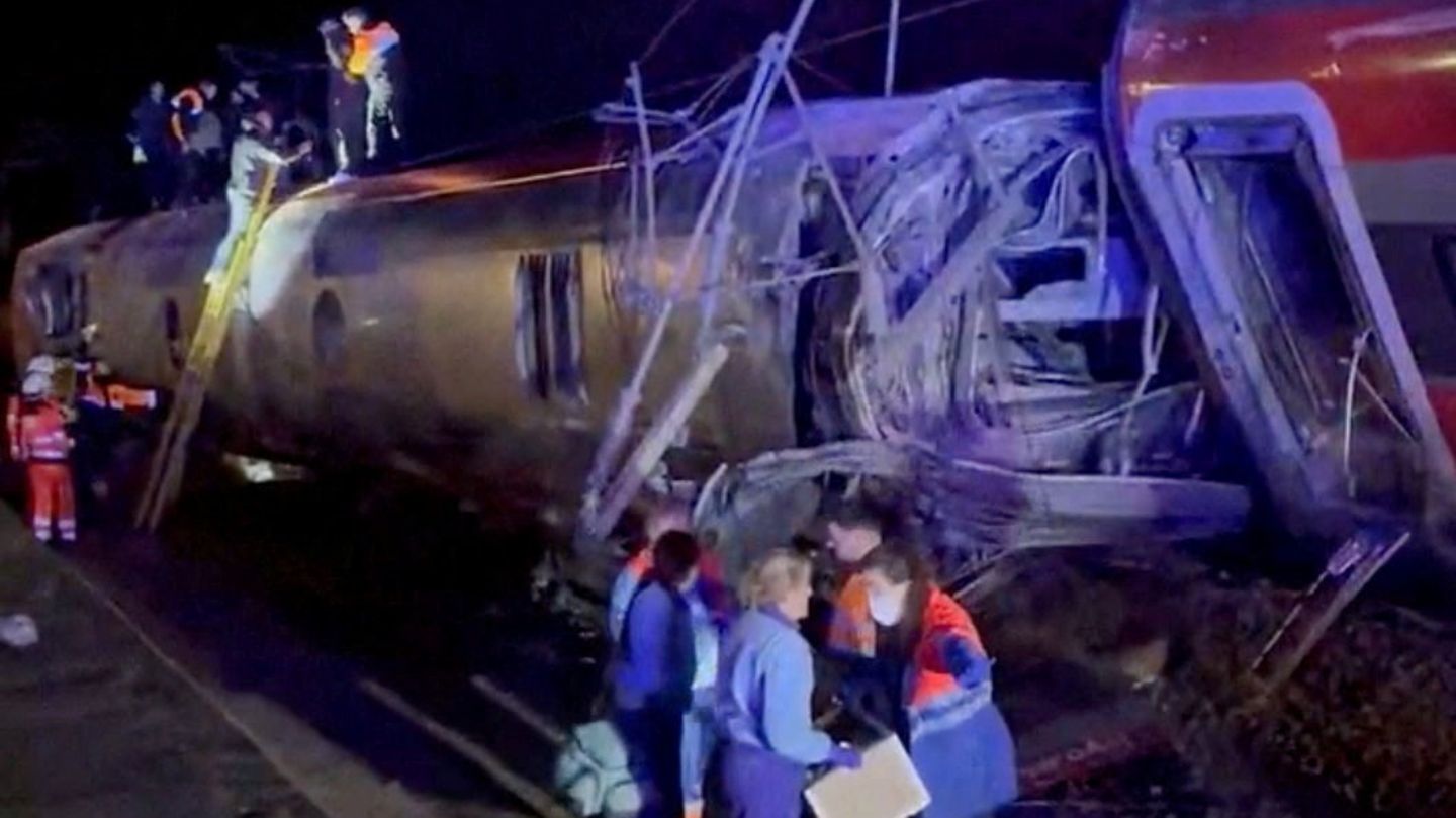 Rettungskräfte im Einsatz auf dem Dach von einem der Züge. Die Waggons sind massiv beschädigt