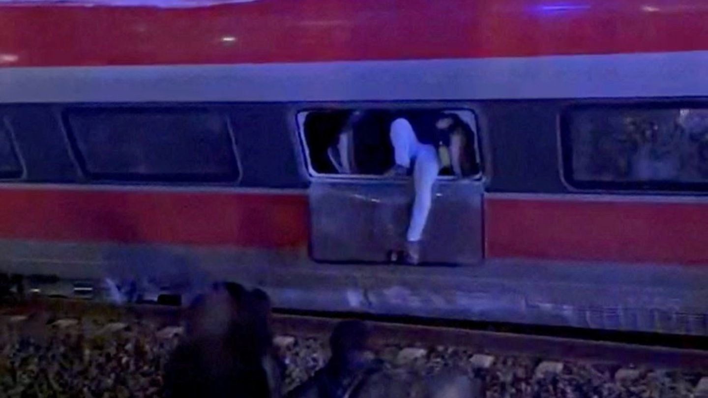 Zu sehen ist, wie eine Person aus dem Fenster des Zuges klettert