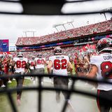 Auftakt eines American-Football-Matches: Die Tampa Bay Buccaneers laufen an den Cheerleadern vorbei auf das Feld, zur obligatorischen Vorstellung der Teams vor dem Beginn des Spiels. Das ungewöhnliche Foto dazu schoss Kyle Zedaker, indem er seine Kamera hinter dem Helmgitter befestigte – und so den Betrachtenden einen beinahe intimen, authentischen Einblick verschaffte, weil er die Perspektive der Profis einnahm   