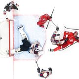 In der Kontinental Hockey League treten die in Rot gewandeten Spieler von Spartak Moskau gegen die Shanghai Dragons an – während der Shanghaier Torwart den Puck unter sich begräbt, geht ein Gegner zu Boden, gekonnt von Sophia Sandurskay fotografiert, wie in einem Eishockey-Stillleben