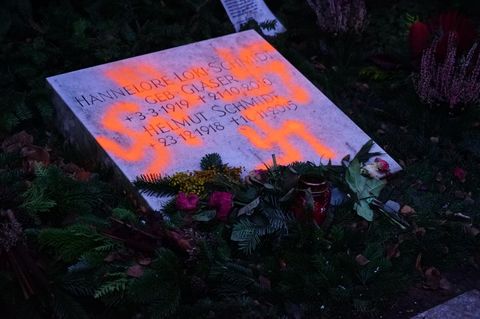 Mit orangenen Hakenkreuzen verunstalteter Grabstein von Loki und Helmut Schmidt