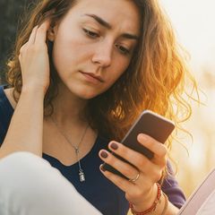 Eine Frau checkt Nachrichten auf Whatsapp