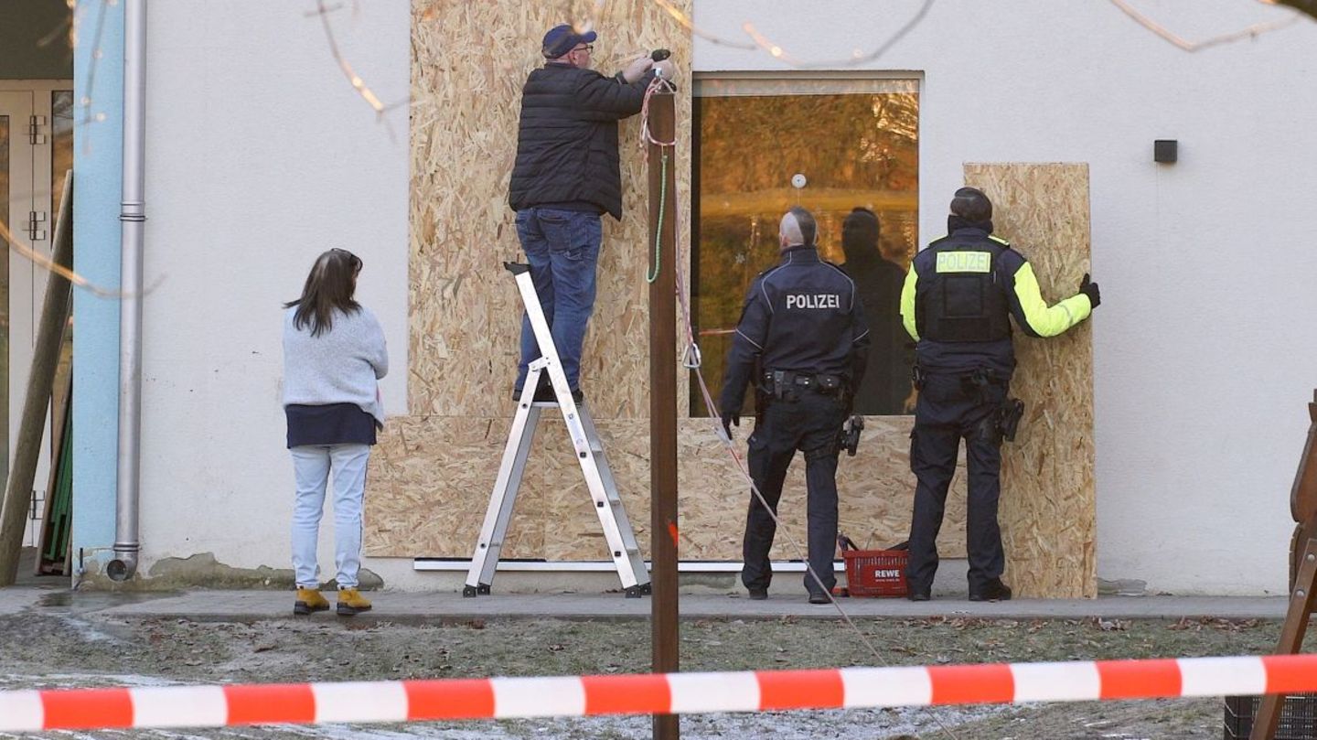 Holzplatten werden an der mutmaßlich beschädigten Terrassentür der Berliner Kita angebracht