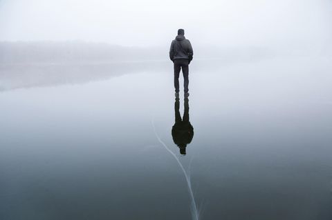Ein Mann steht auf einem gefrorenen See