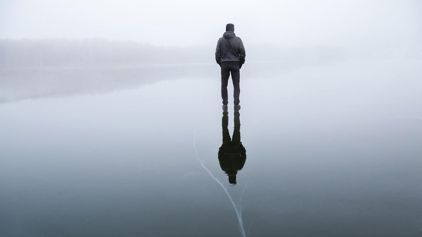 Ein Mann steht auf einem gefrorenen See