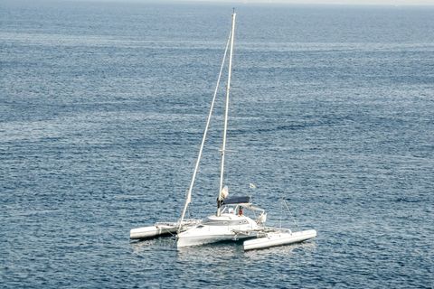 Ein Trimaran fährt unter Motor übers Meer