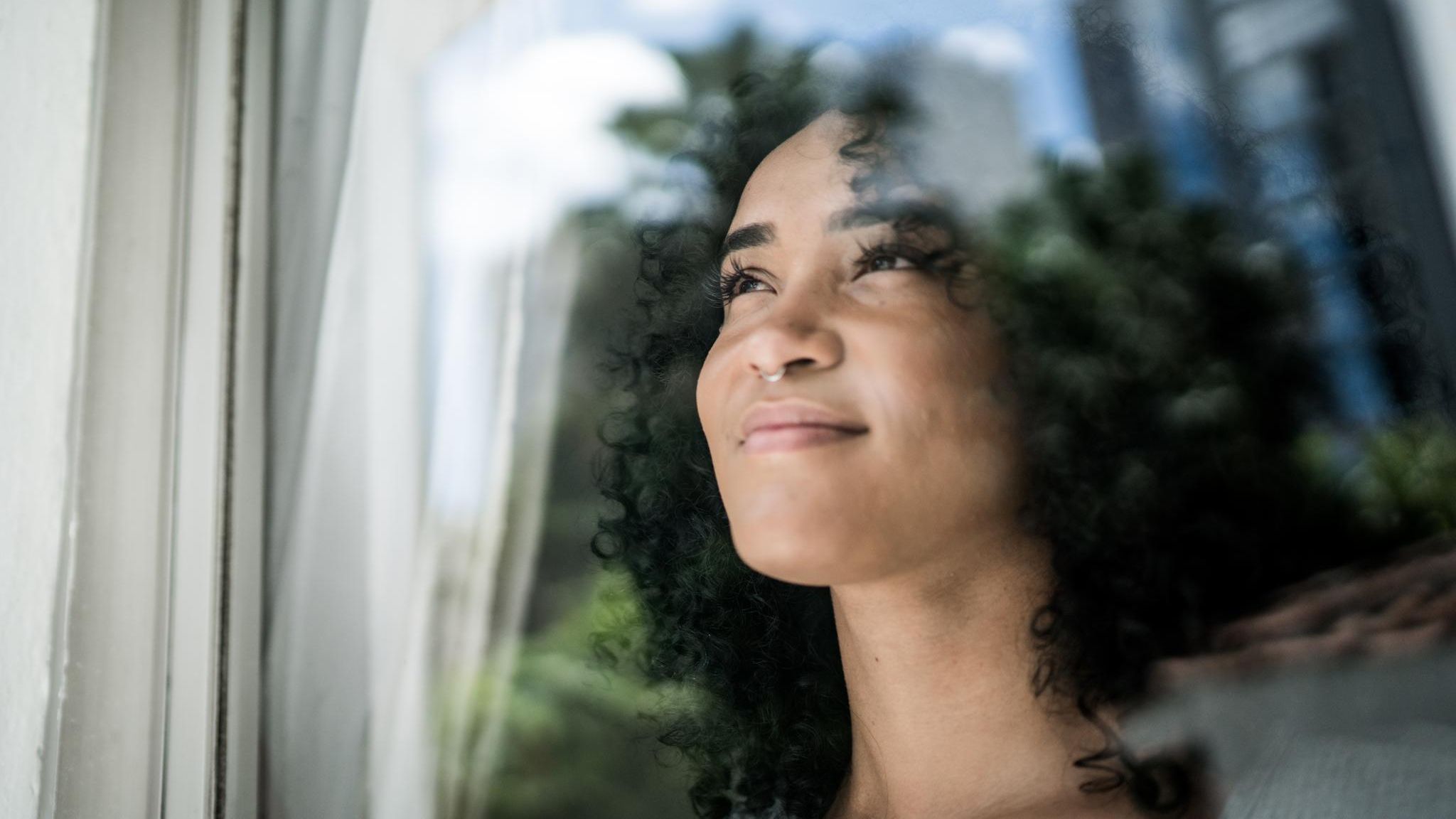 Junge Frau schaut aus dem Fenster