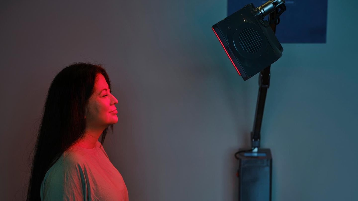 Deal News: Eine Frau sitzt vor einem Infrarotstrahler
