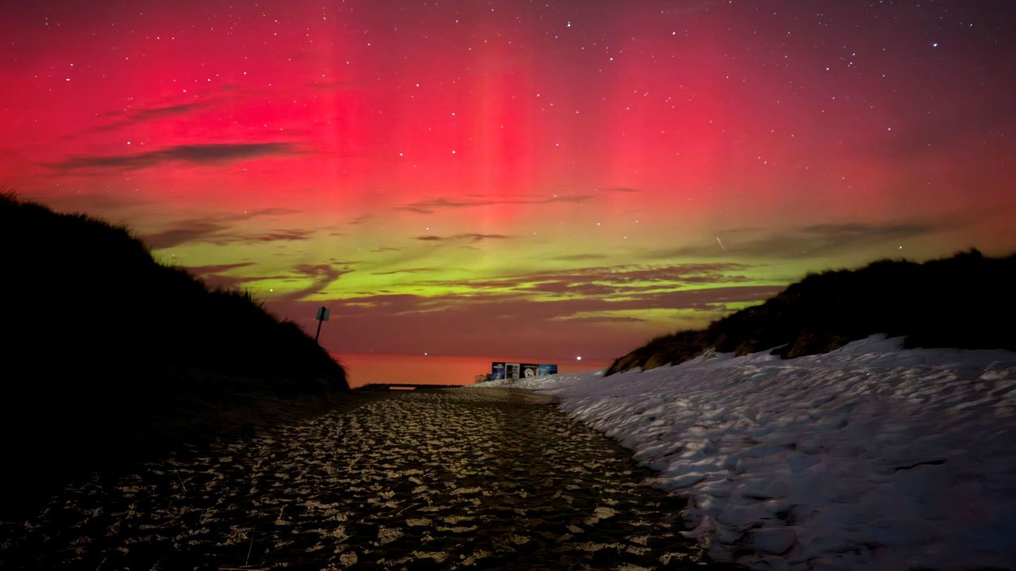 Schnee, Sand und bunte Lichter bilden einen seltenen Anblick auf der Nordseeinsel Norderney. Foto: Volker Bartels/-/dpa