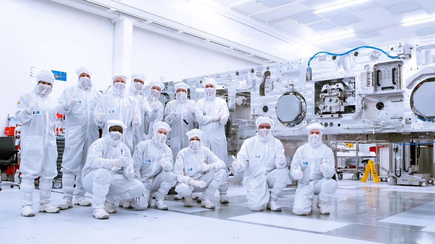 ASML-Mitarbeiter in Veldhoven posieren in weißen Schutzanzügen in der Produktion, ihre Maschinen sind wichtig für Trump