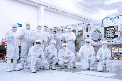 ASML-Mitarbeiter in Veldhoven posieren in weißen Schutzanzügen in der Produktion, ihre Maschinen sind wichtig für Trump