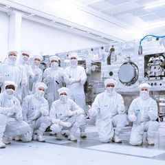 ASML-Mitarbeiter in Veldhoven posieren in weißen Schutzanzügen in der Produktion, ihre Maschinen sind wichtig für Trump