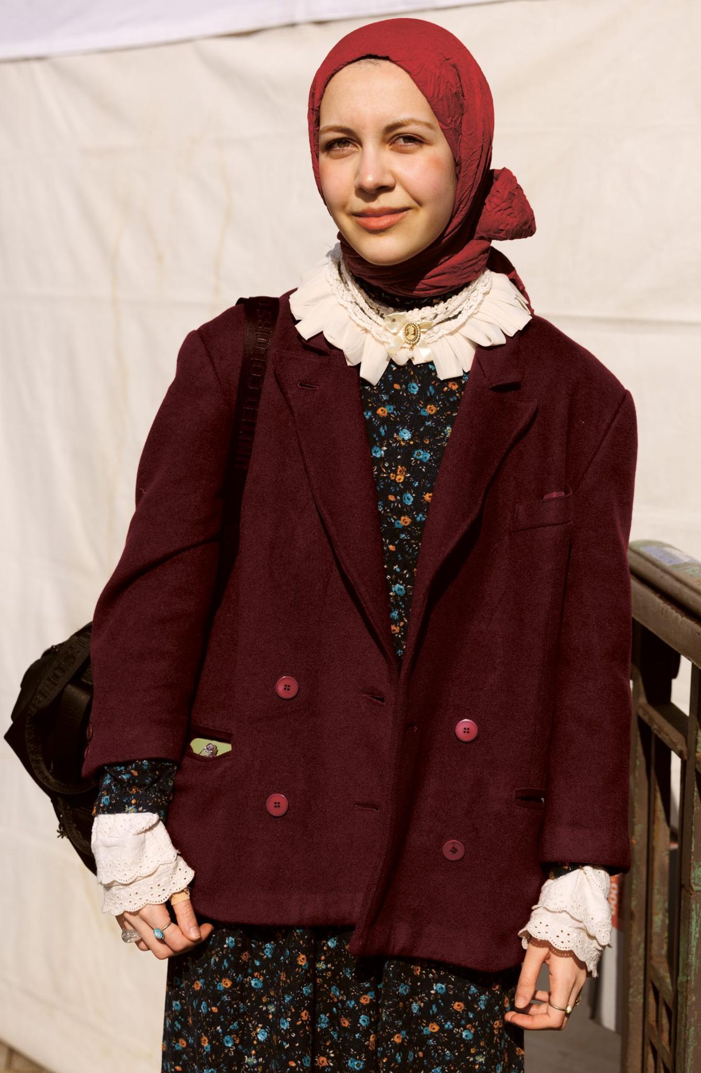 Eine junge Frau mit Kopftuch und Spitzenbluse