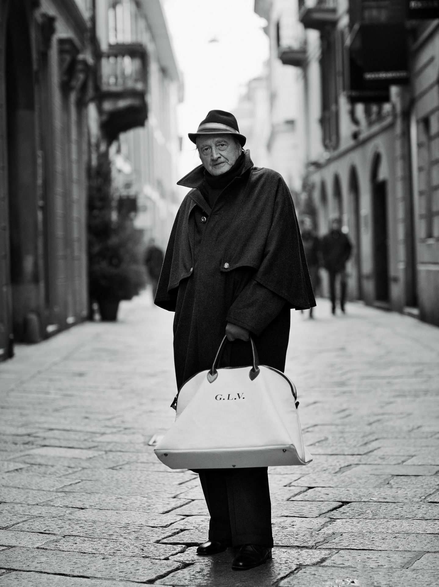 Ein älterer Mann mit Hut und Tasche