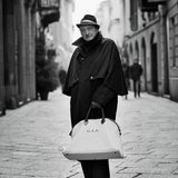 Ein älterer Mann mit Hut und Tasche