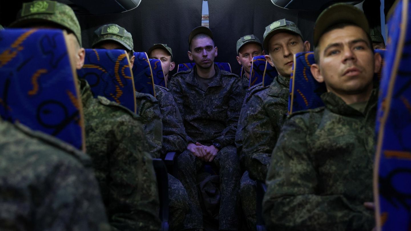 Soldaten aus Russland sitzen nach einem Gefangenenaustausch in einem Bus zurück in Richtung Heimat