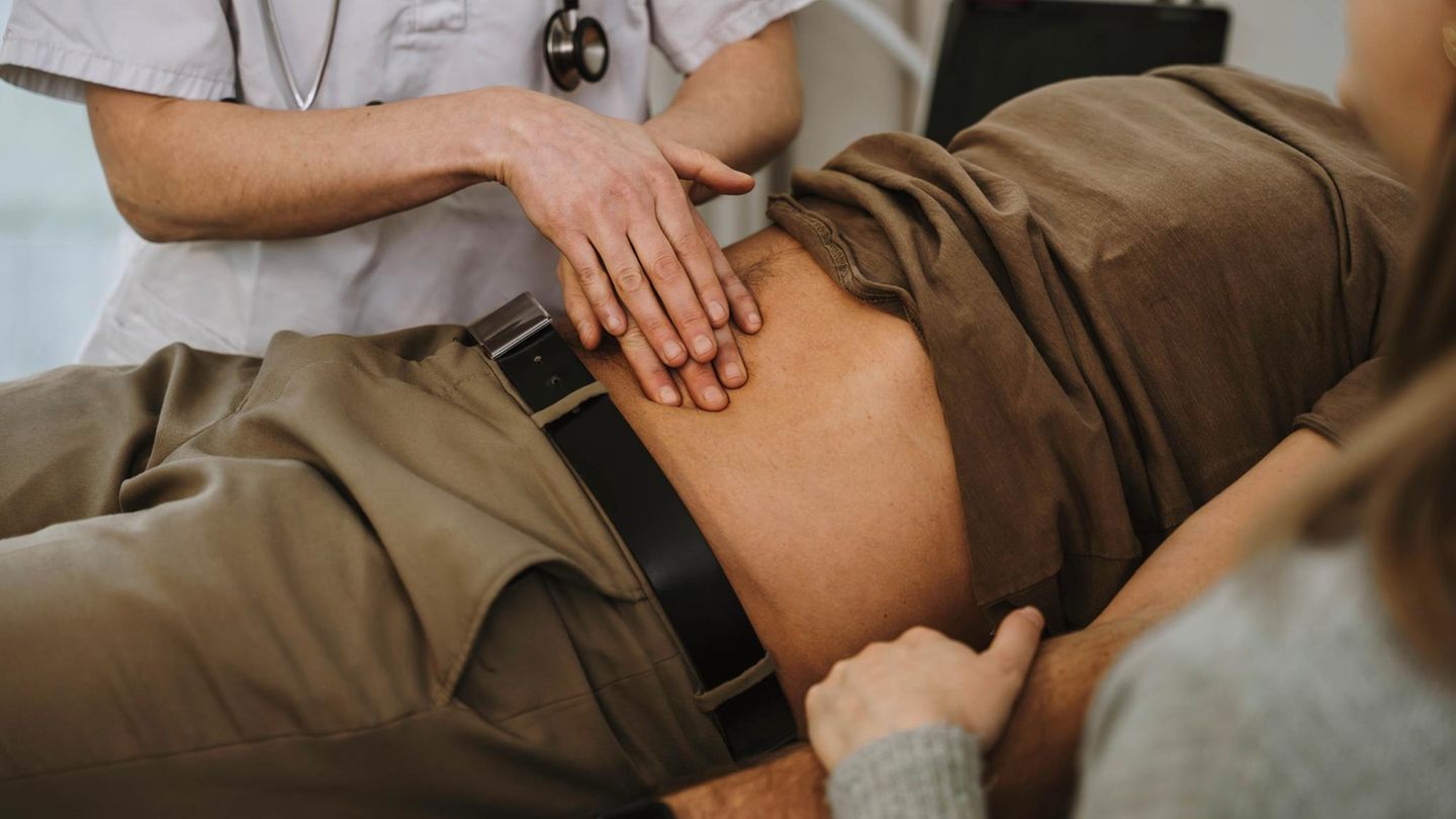 einem jungen Mann wird der Bauch abgetastet