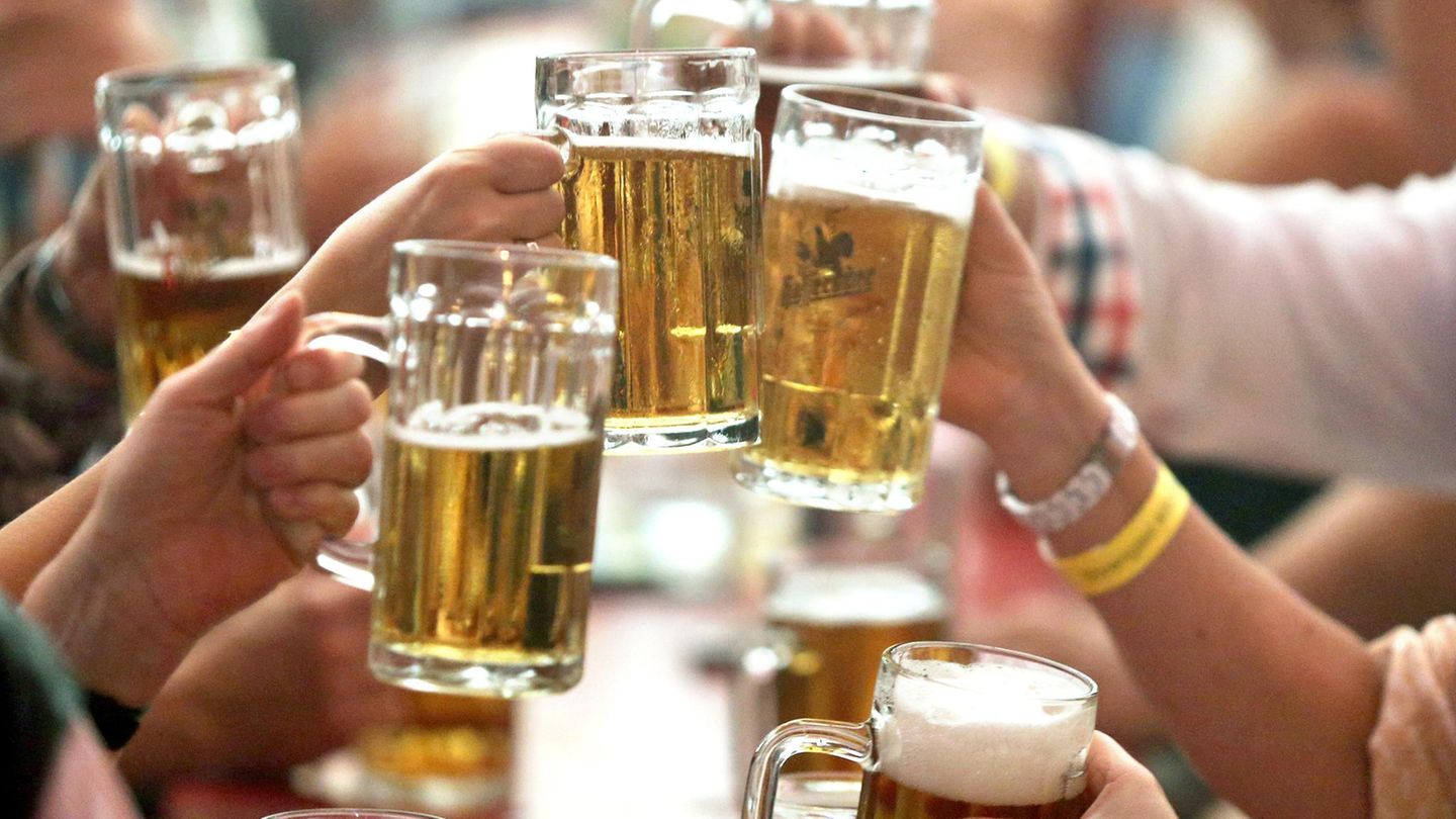 Mehrere Menschen stoßen mit Bier an
