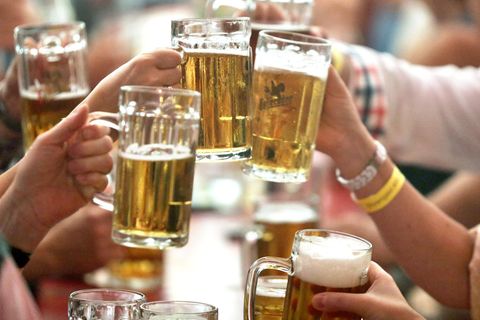 Mehrere Menschen stoßen mit Bier an