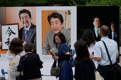 Menschen betrachten Fotos des ehemaligen japanischen Premierministers Shinzo Abe