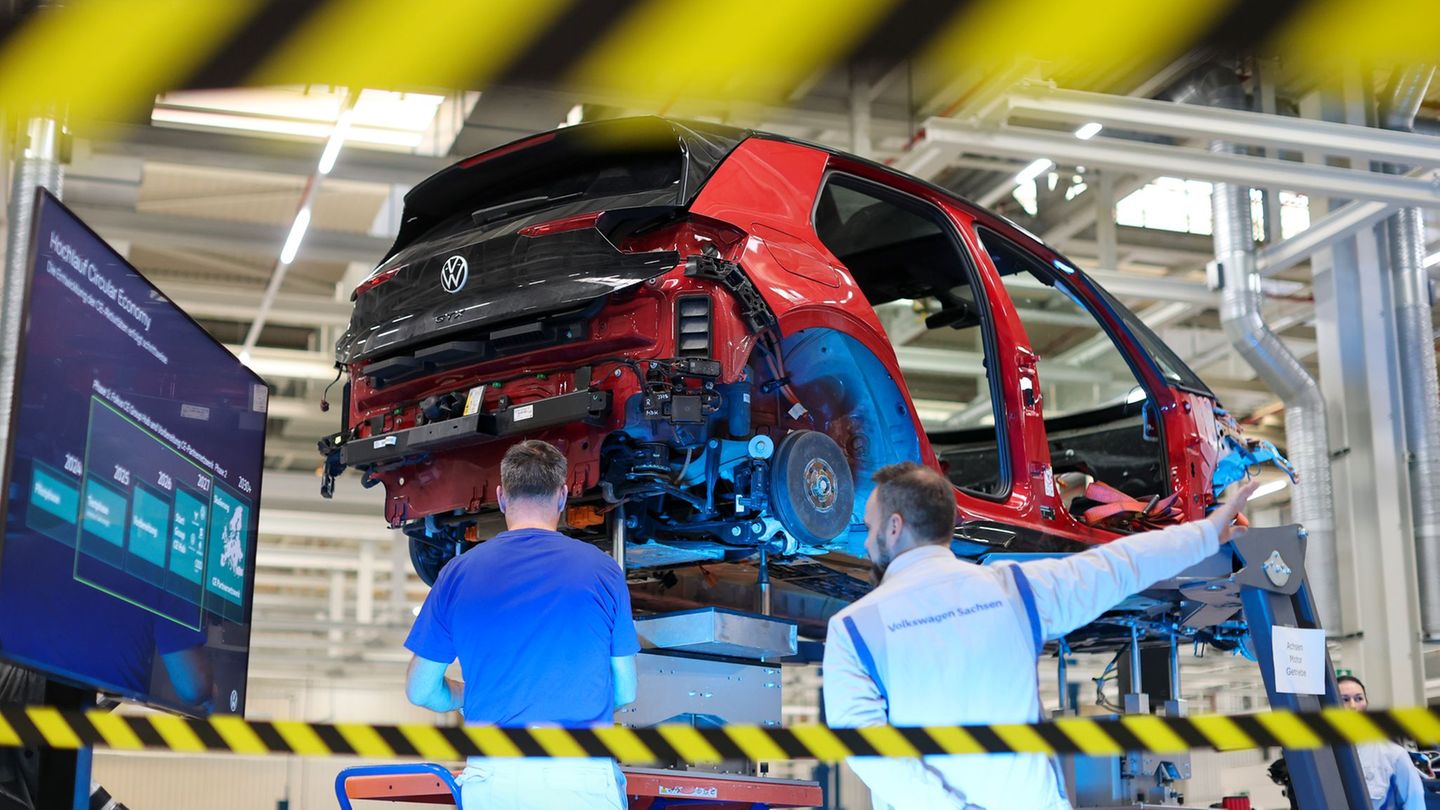 Mitarbeiter von VW Zwickau zerlegen einen VW ID.3. Foto: Jan Woitas/dpa