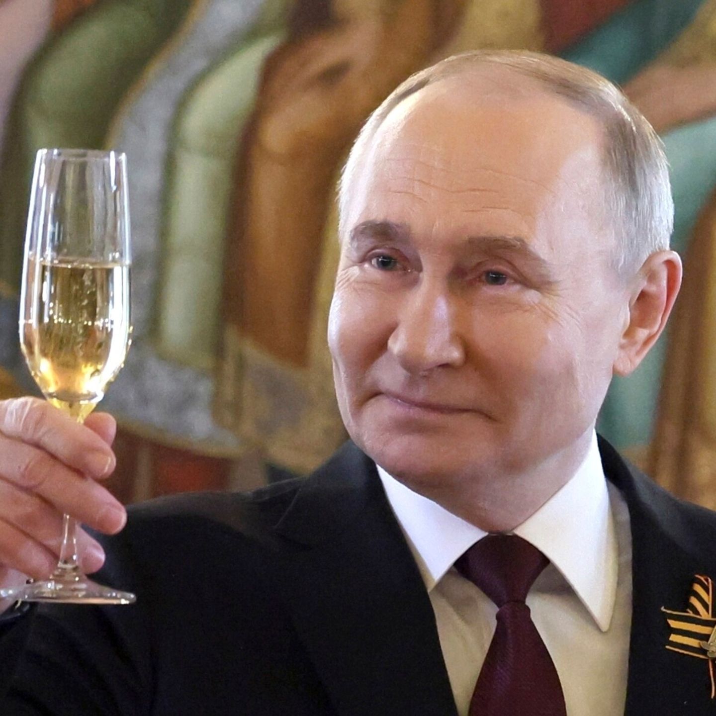 Putin hebt ein Glas Champagner