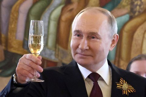 Putin hebt ein Glas Champagner