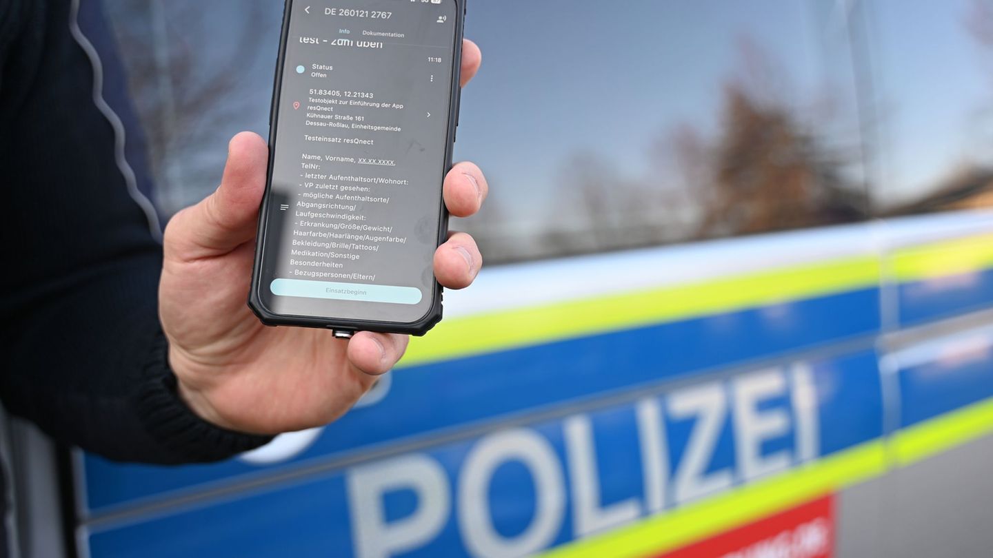 Ein Polizeibeamter aus Sachsen-Anhalt hält ein Smartphone mit der App "resQnect" an der Polizeiinspektion in Dessau-Roßlau in de