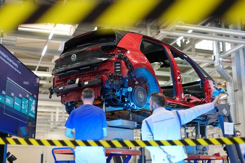 Mitarbeiter von Volkswagen in Zwickau zerlegen einen VW ID.3. Foto: Jan Woitas/dpa