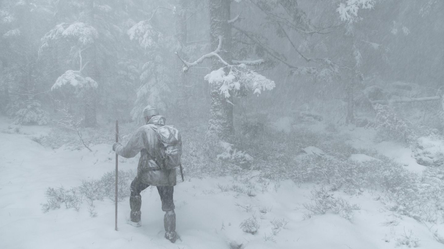 Wald Mann stapft durch Winterlandschaft