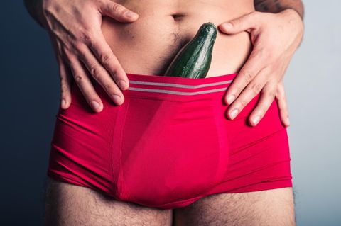 Penis-Symbolbild: Einem Mann ragt eine Gurke aus der roten Unterhose