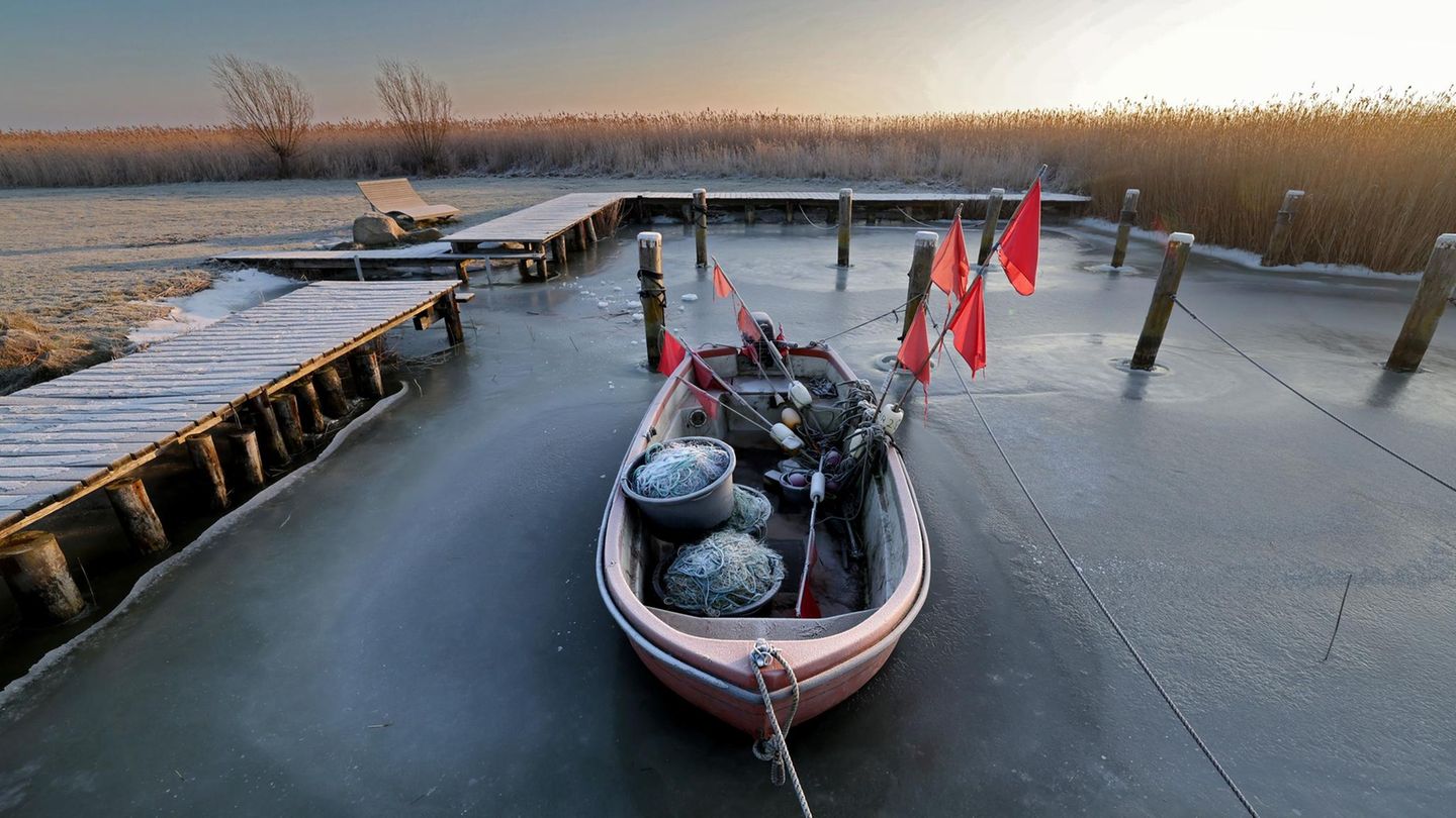 Ahrenshoop, Deutschland. Im Boddenhafen liegt ein Fischerboot im Eis. Einen fetten Fang wird die Nussschale heute sehr wahrscheinlich nicht mehr machen