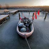 Ahrenshoop, Deutschland. Im Boddenhafen liegt ein Fischerboot im Eis. Einen fetten Fang wird die Nussschale heute sehr wahrscheinlich nicht mehr machen